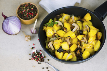 fried potatoes with Japanese shiitake mushrooms and onions in a frying pan