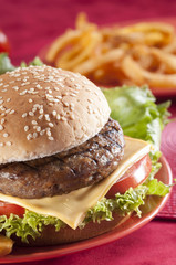 Beef Burger with bell pepper and lettuce with cherry red and yellow tomato on Red background 