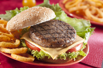 Beef Burger with bell pepper and lettuce with cherry red and yellow tomato on Red background 