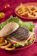 Beef Burger with bell pepper and lettuce with cherry red and yellow tomato on Red background 
