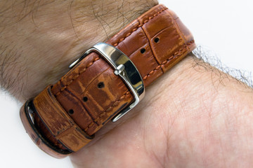 The watch strap is fastened to the wrist of a man. © Alexander