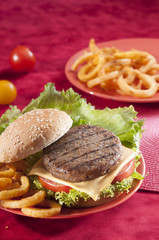 Beef Burger with bell pepper and lettuce with cherry red and yellow tomato on Red background 