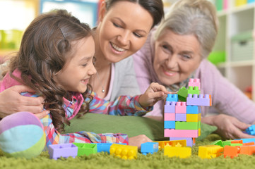 Happy smiling family playing with colorful plastic blocks