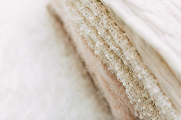 Stack of cozy knitted sweaters on a table. Retro style. Warm concept