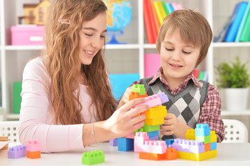 Obraz na płótnie Canvas Woman and boy playing blocks game together