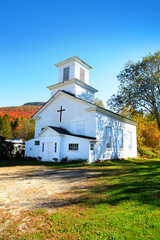 Fototapeta na wymiar Small church in typical New England town with fall foliage