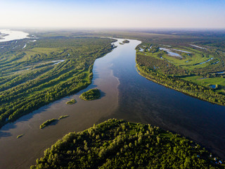Ob river flows through the taiga. River landscape, beautiful sky reflection in water. Vasyugan Swamp from aerial view. Tomsk region, Siberia, Russia