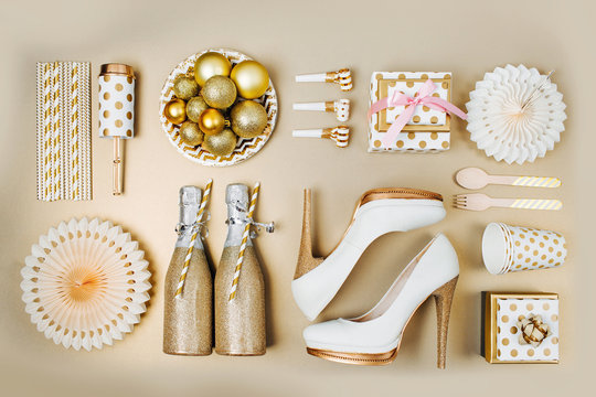 Flat lay stylish set: champagne, gift, female shoes, christmas balls and golden holiday decoration. Flat lay, top view.
