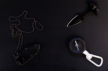 Knife and compass. Tourist accessories on a black background.