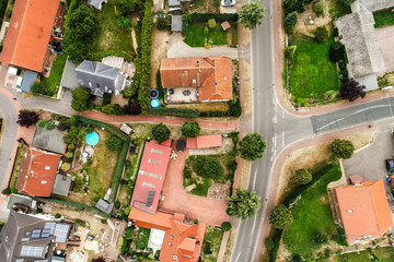 Fototapeta na wymiar Vertical view from the air with vertical view of houses, roofs and streets of a village in northern Germany
