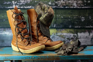 Fotobehang Leather lace up hunting boots with camo hat and gloves © CLShebley
