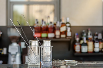Glasses for making cocktails on bar counter in modern restaurant
