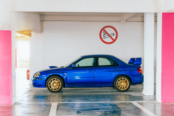 Voiture de sport aux couleurs pop dans un parking