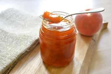Peach apricot jam in a jar and spoon