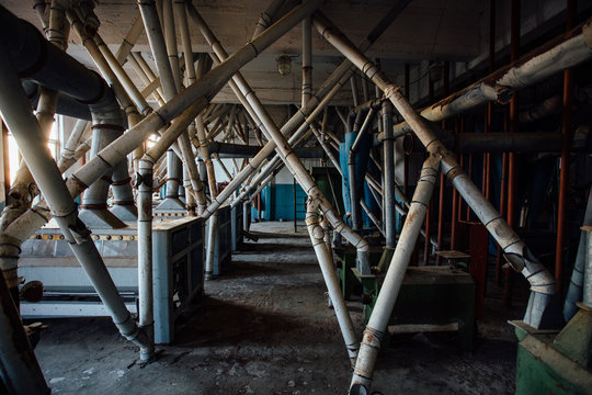 Abandoned Flour Milling Factory. Old Rusty Roller Mill Equipment With Pipeline