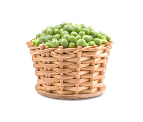 Green fresh peas in a wicker basket on a white isolated background