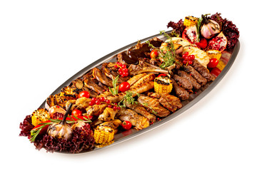 Closeup metal dish of meat assortment set of grilled pork, beef, chicken with vegetables isolated at white background.