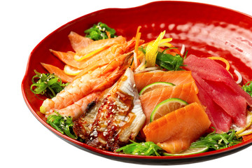 Isolated plate of sashimi including tuna, shrims, salmon served with soy sauce isolated at white background.