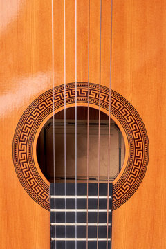 Ukulele guitar close up. Detail of yellow acoustic guitar, vertical image. Vintage musical guitar background.
