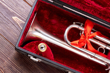 Christmas silver trumpet in box. Brass trumpet in velvet case. Traditional musical instrument.