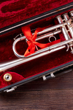 Trumpet or cornet in velvet case. Traditional trumpet with red ribbon, top view. Vintage musical instrument.