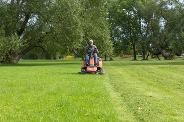 lawn mower tractor working in the town park