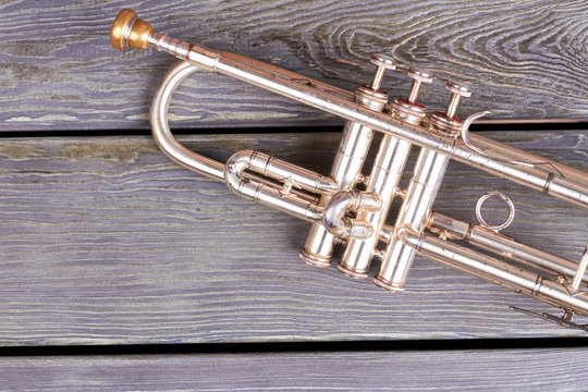 Vintage trumpet with clipping path. Old trumpet on wooden boards. Retro musical background.