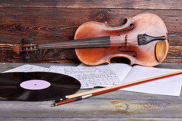 Musical background in vintage style. Violin, vinyl record and sheets of musical notes. Retro musical equipment.