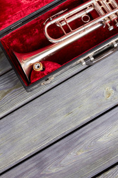 Trumpet in box and copy space. Classical jazzy instrument on wooden boards. Orchestral wind instrument.