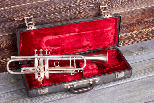 Trumpet in red velvet case. Classical jazzy instrument. Symphonic music equipment.