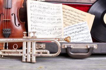 Vintage musical instruments background. Old trumpet, violin, musical notes and vinyl record close up. Retro music style.