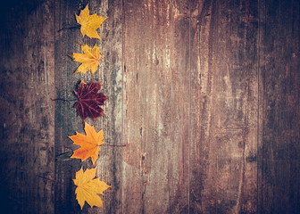 Autumn composition.Frame made of аutumn red and orange leaves on wooden vintage rustic background. Fall background. Flat lay, top view, copy space 