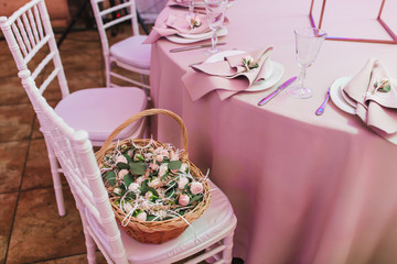Wedding table setting in pink biege colors decorated with natural flowers in basket