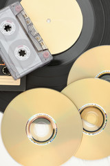DVD discs, audio cassettes and vinyl record. Compact discs, audio tape and vinyl plate close up,...