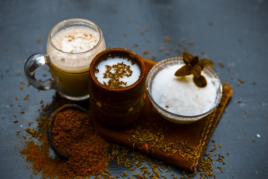 Traditional summer drink i.e. is most popular in Asia and India i.e. Chas or chaas or buttermilk or chhaachh in a clay glass with curd and coriander powder and salt on wooden surface,Close up.