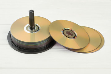 Stack of compact discs on white background. Group of blank disks on wooden surface. Digital storage of information.