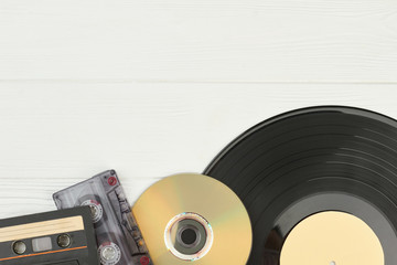 Musical storage devices and copy space. Old audio cassette tapes, compact disc and vinyl record on...