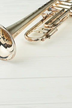 Old silver trumpet and copy space. Trumpet on light background, vertical image. Classical instrument of orchestra.