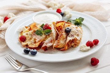 closeup of pancakes with cottage cheeseand strawberry, blueberry on plate on white plate background, decorated with mint leaves