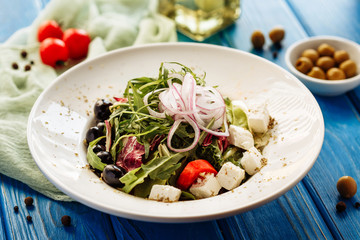 Salad with arugula, tomato, cheese and red onion. Whole plate view