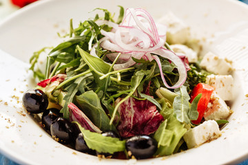 Salad with arugula, tomato, cheese and red onion. Close view for restaurant menu