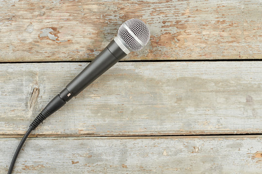 Microphone on old wooden background. Dynamic microphone on wooden boards and copy space.
