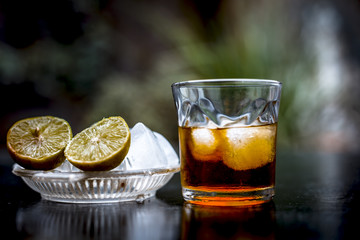 Close up of hangover remedy i.e. lemon juice on wooden surface with Scotch or Scotch whiskey or Grain whiskey.