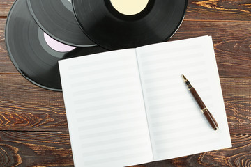 Vinyl records and notebook for music notes. Blank musical note paper, pen and vinyl records....