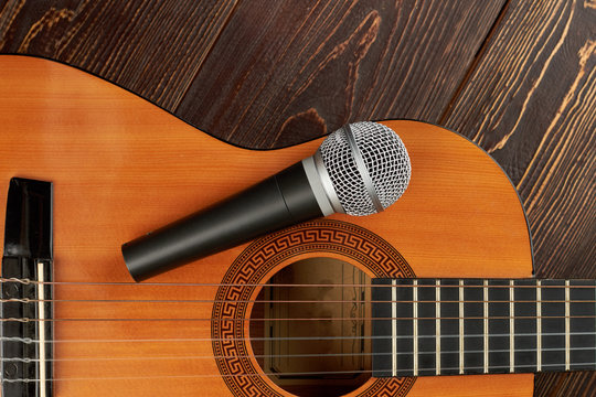 Acoustic guitar with microphone. Grey microphone on classical guitar. Traditional musical instrument.