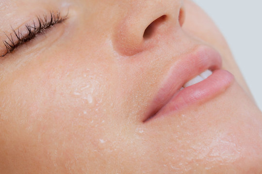 The procedure of steaming the skin of the face of a young woman before cleaning the skin in a cosmetology salon.