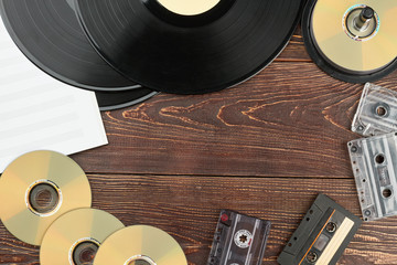 Frame from vintage musical discs and records. Vinyl records, compact discs, analogue cassettes, musical notes and copy space. Retro music storage devices.