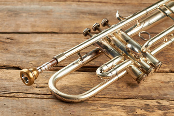 Old classical trumpet close up. Traditional wind instrument on old wooden floor. - obrazy, fototapety, plakaty