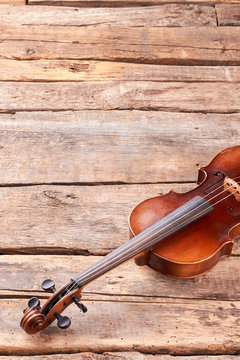 Violin on wooden planks and copy space. Antique violin on rustic wooden surface with space for text. Classical instrument of orchestra.