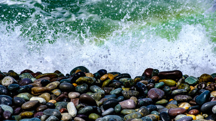 crashing waves on colourful rocks